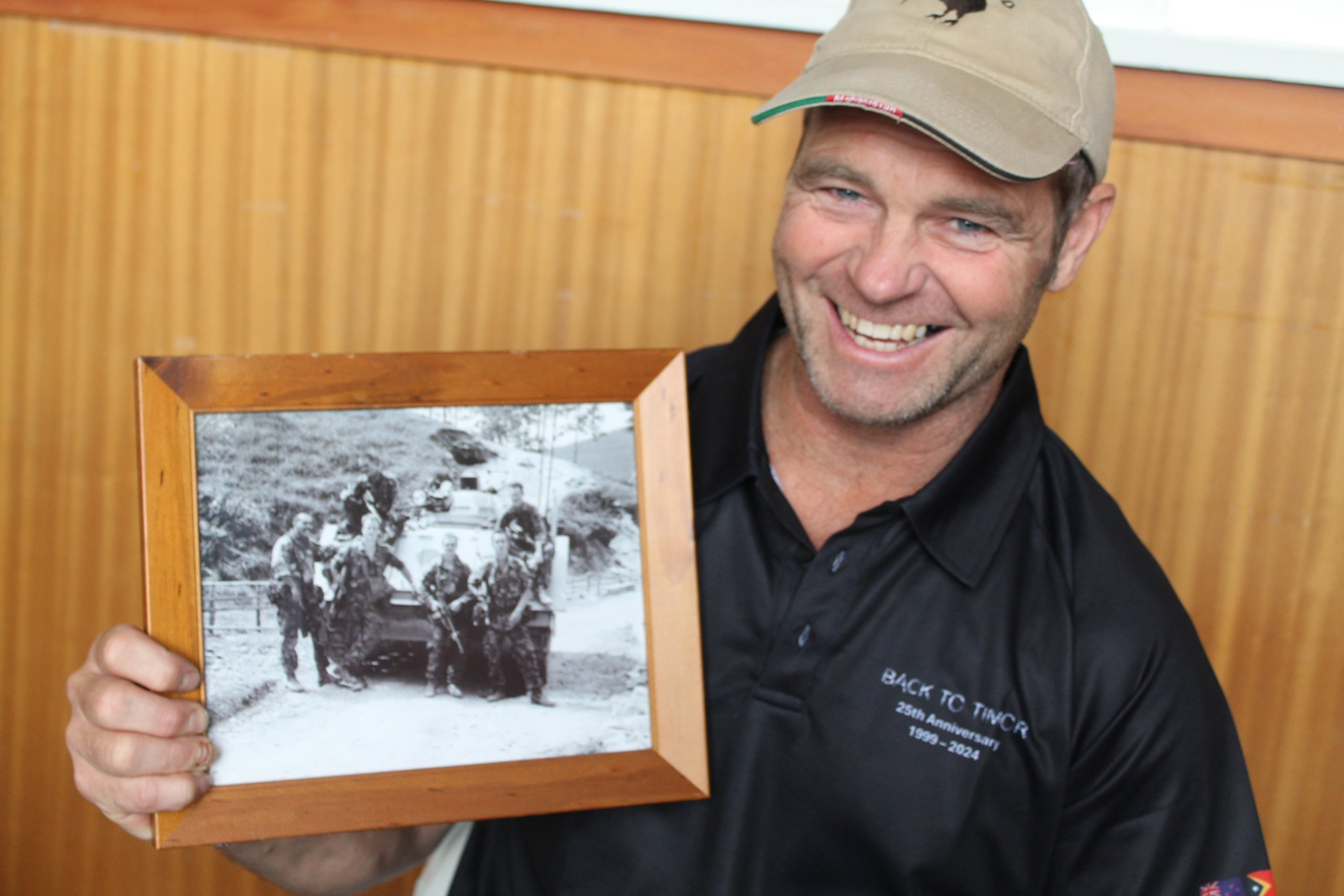 Aaron Horrell holds a photo of his patrol in East Timor, deployed in 2000. Photos: supplied