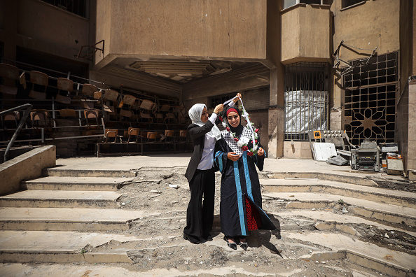 Palestinian researcher Nevin Yassin receives congratulations from a friend after defending her...