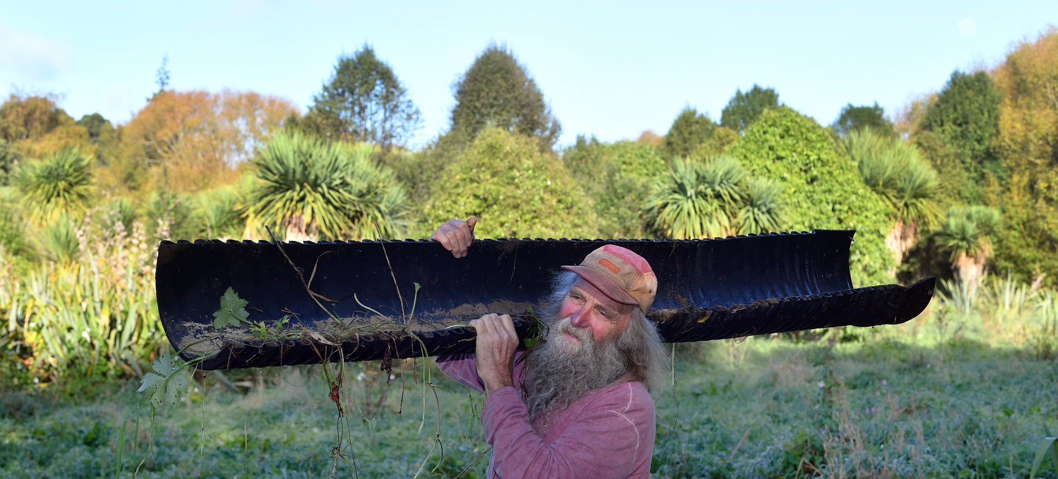 Community volunteer Hendrik Koch carries garbage out of the stream next to a 2ha area he and...