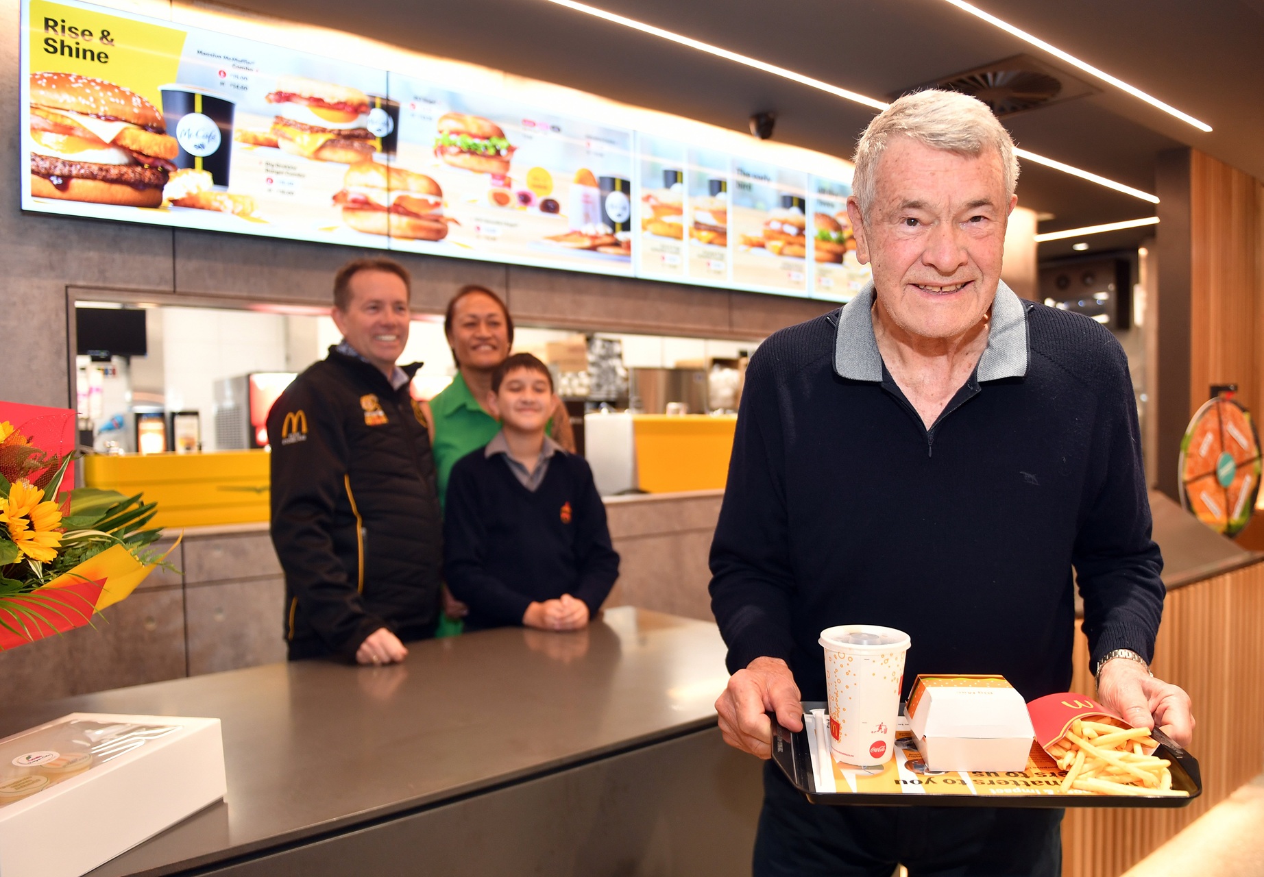 Ray Stonelake sen is served the first meal at the new Green Island McDonald’s by his son Justin,...