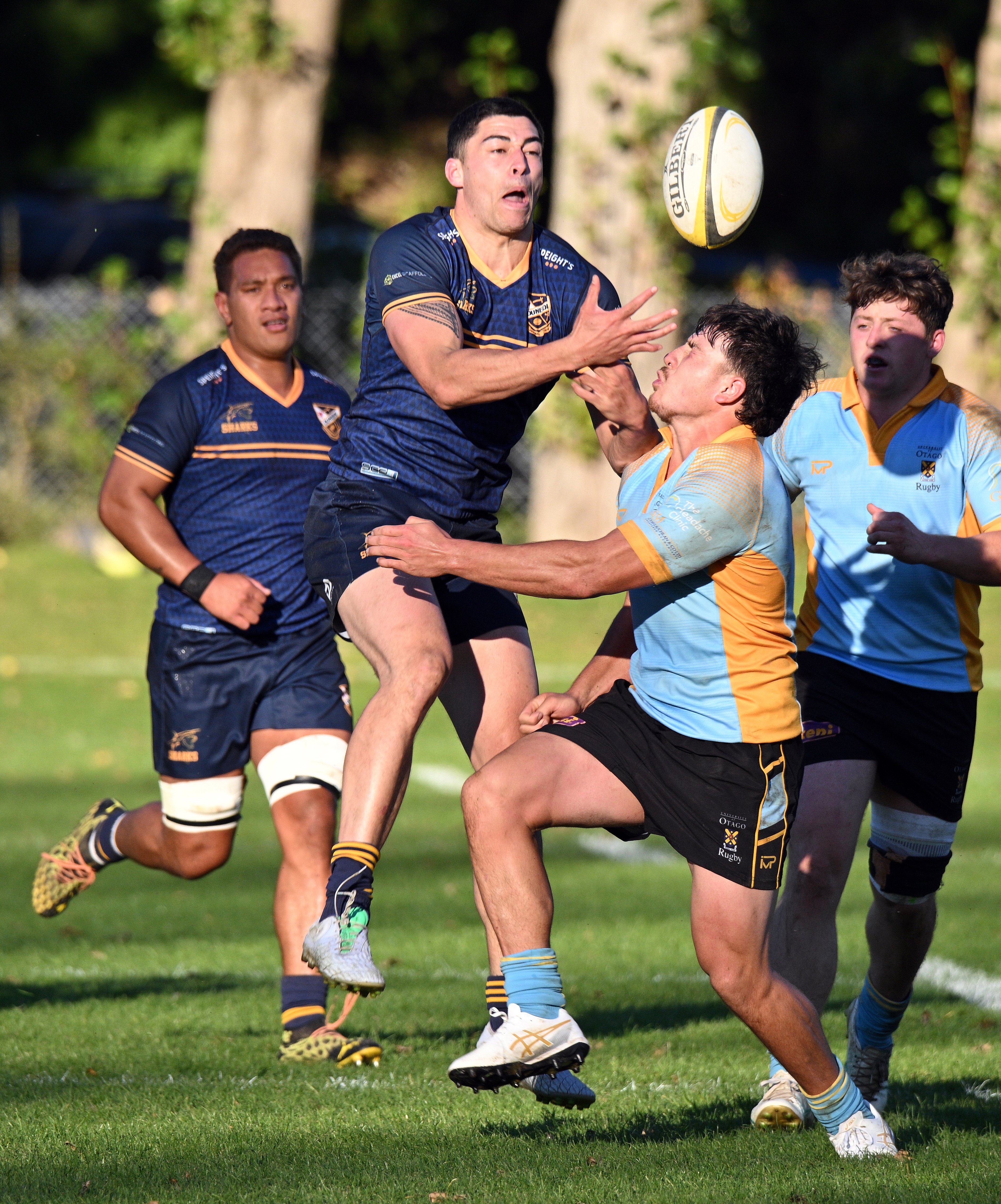 Dunedin winger Oscar Schmidt-Uili attempts to catch the ball despite the efforts of University's...