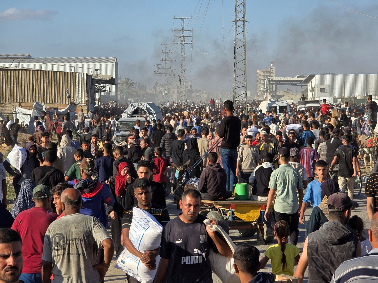 Palestinians gather at an aid distribution centre in Deir Al-Balah, in the Gaza Strip. Photo:...