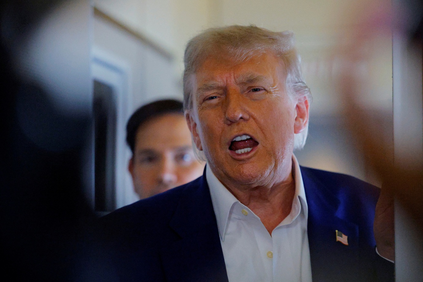 US President Donald Trump speaks to reporters on board Air Force One en route to the NATO summit...
