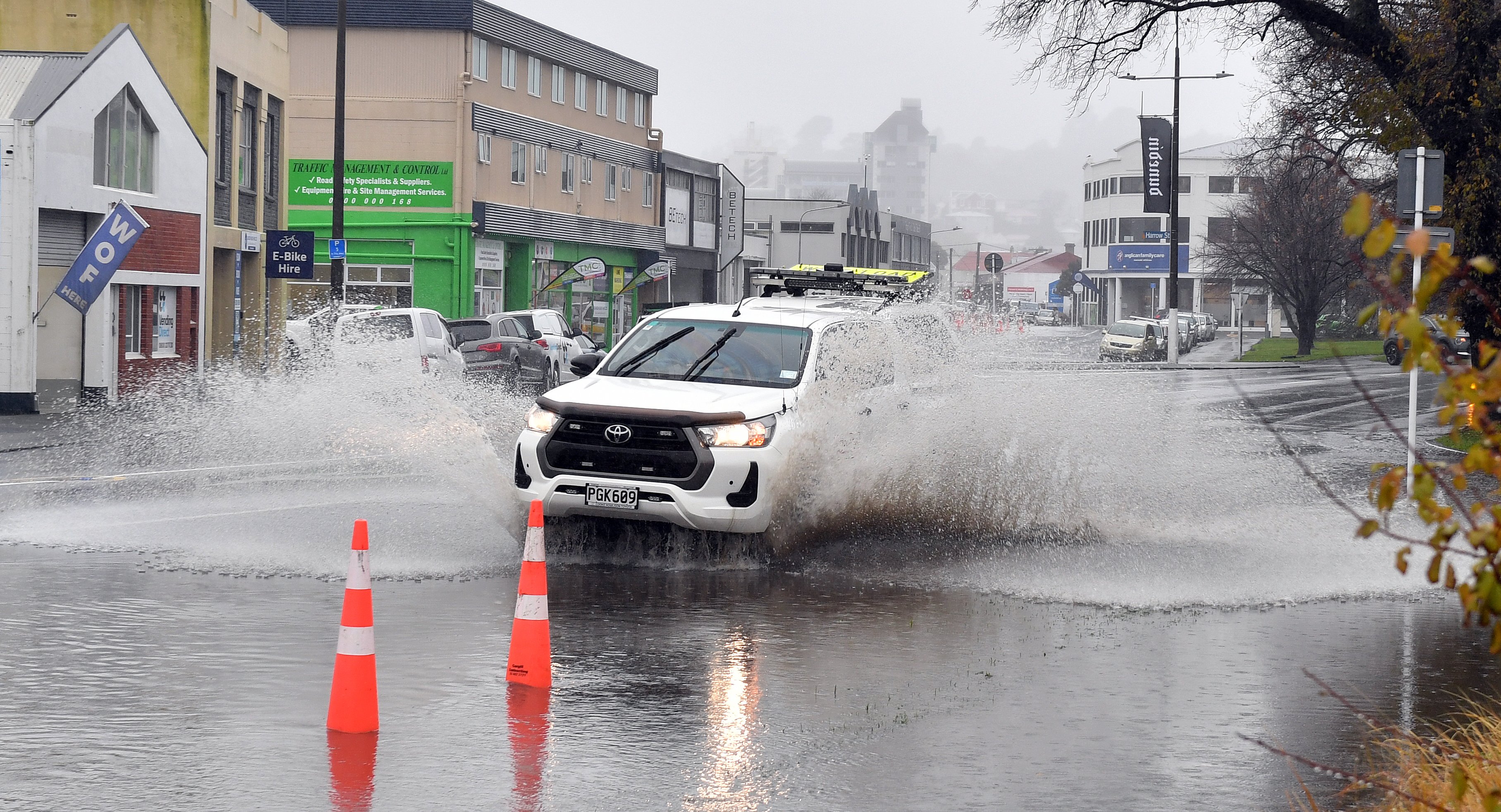 A ute is driven through pooling water in a trouble spot in Anzac Ave following persistent rain...