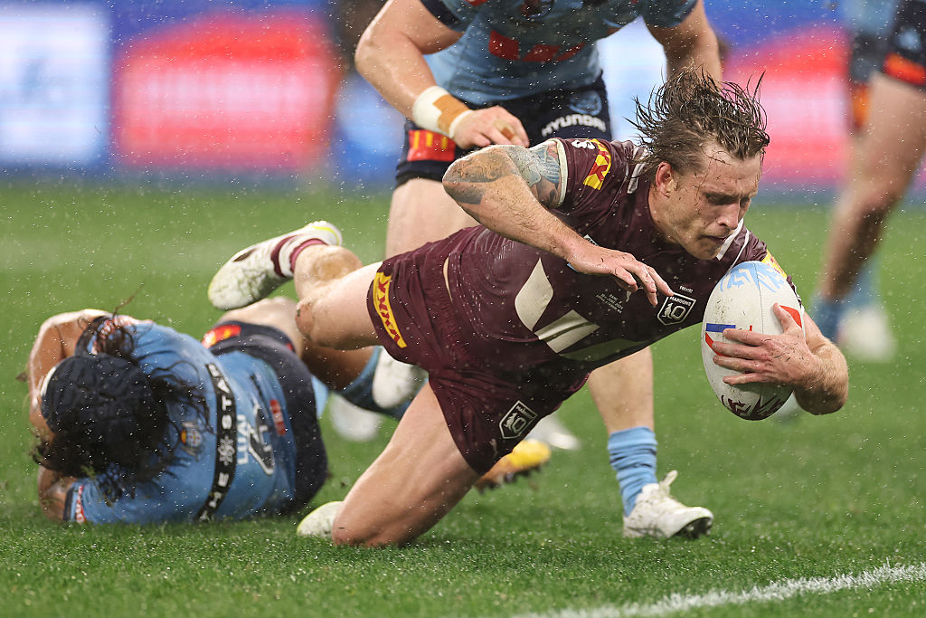 Maroons captain Cameron Munster scores in the tackle of Blues player Jarome Luai in the second...