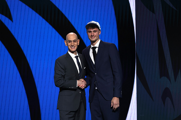 Cooper Flagg (right) shakes hands with NBA commissioner Adam Silver after being selected first...