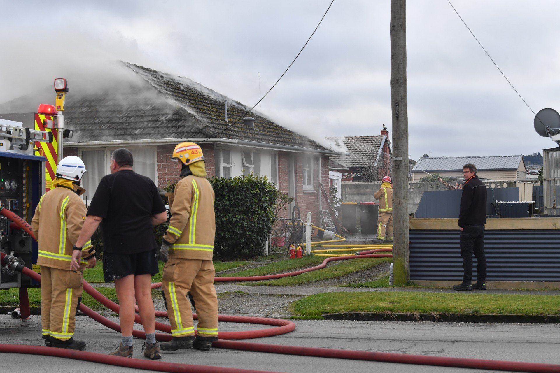 Firefighters extinguish a house fire in Gore yesterday afternoon. PHOTO: STEPHEN JAQUIERY
