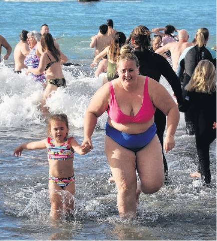 Chelsea Sandersen of Kaiapoi runs from the sea with her daughter Tui, 4. PHOTO: JOHN COSGROVE