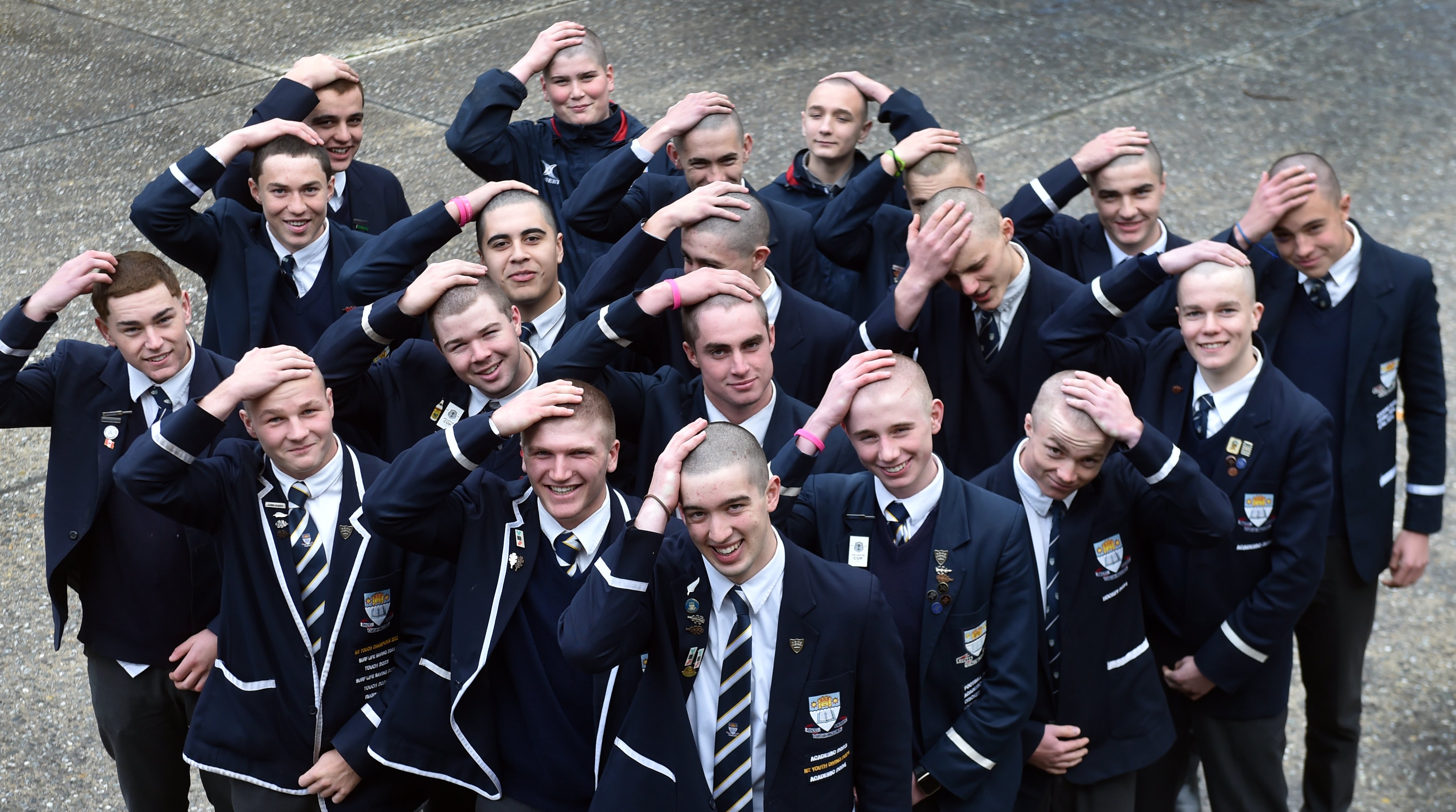Otago Boys’ High School students rub their freshly shaved heads. PHOTO: PETER MCINTOSH