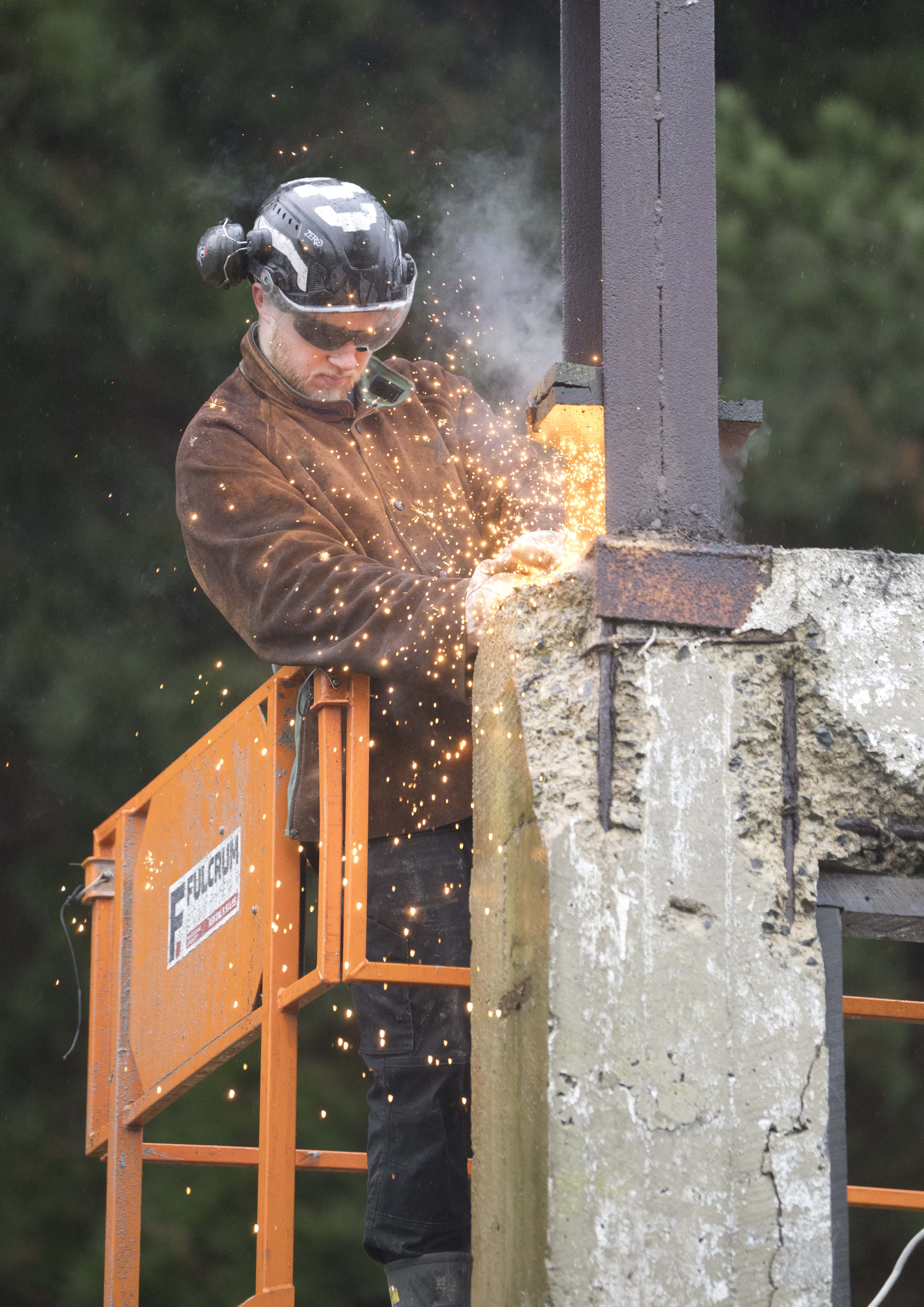 Construction workers begin the partial demolition and restoration of the historic Sims building,...