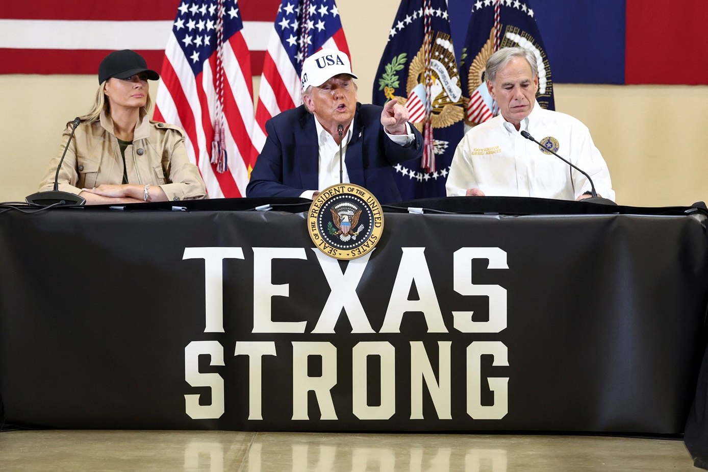 US President Donald Trump (C), first lady Melania Trump (L) and Texas Governor Greg Abbott...