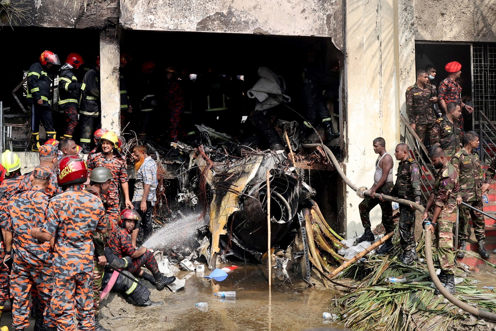 Firefighters and army personnel work next to the aircraft wreckage following the crash. Photo:...