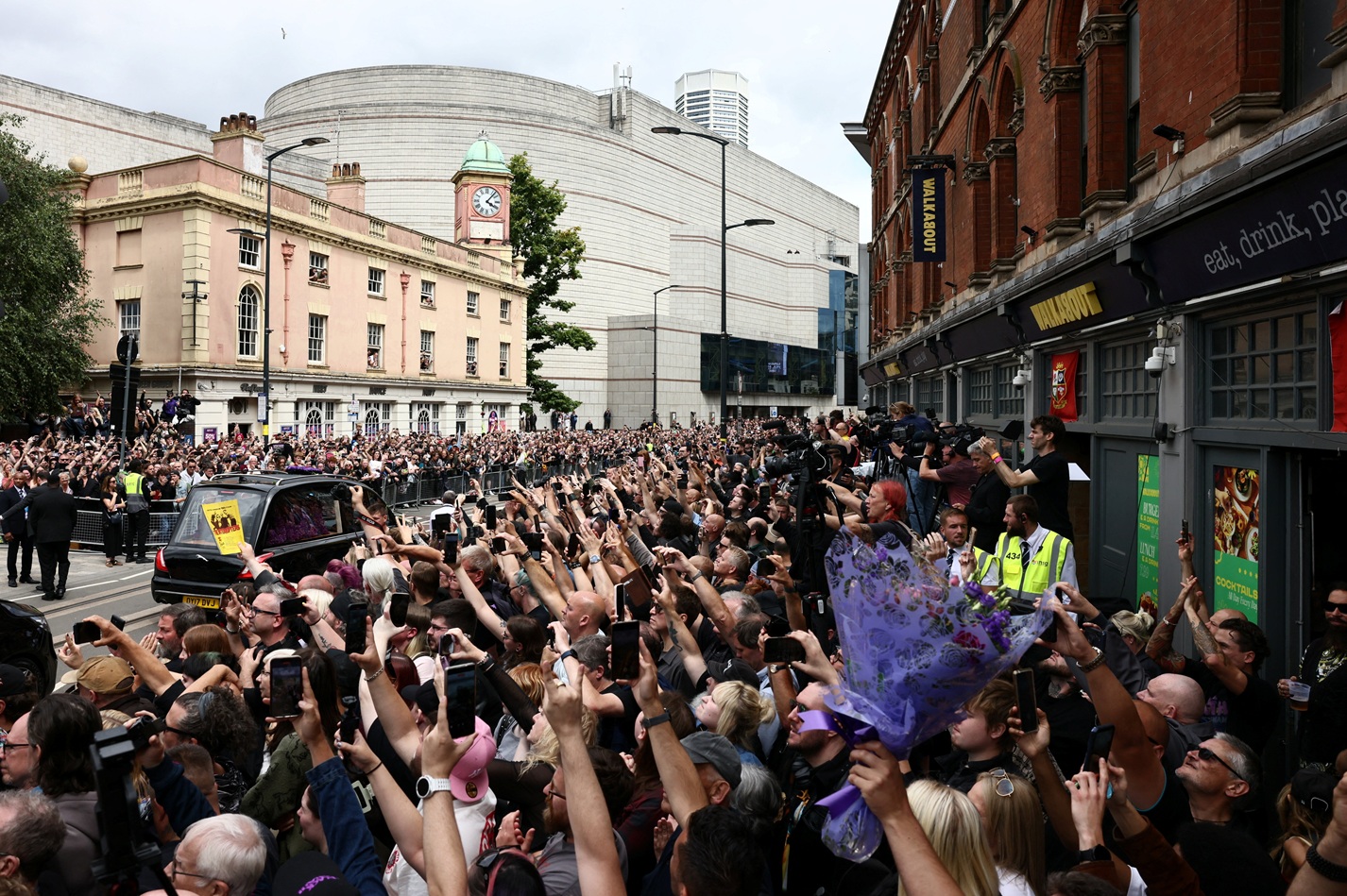 Crowds gather at the Black Sabbath Bridge as the funeral cortege of Ozzy Osbourne passes through...