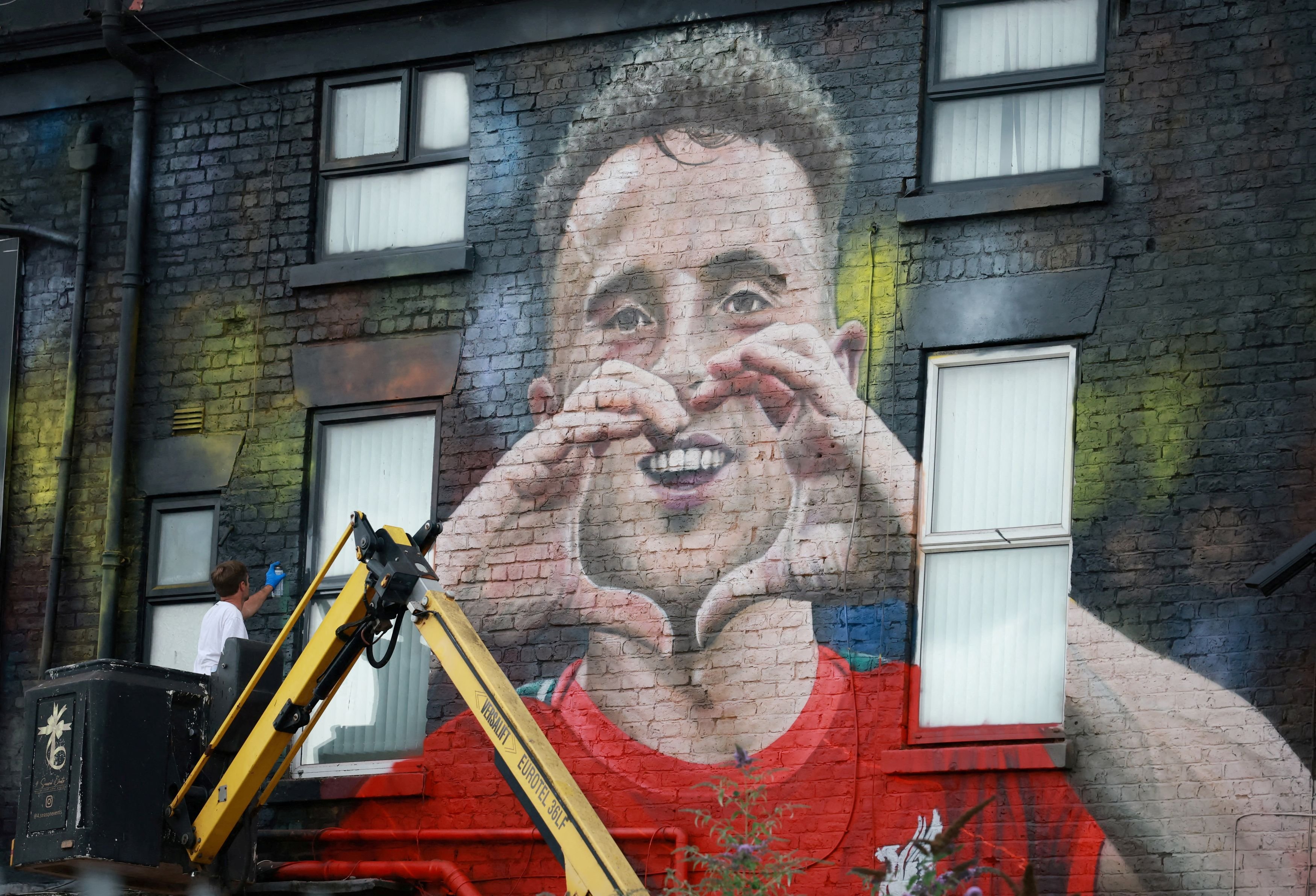 Liverpool artist John Culshaw works on a mural of late Portugal and Liverpool player Diogo Jota...
