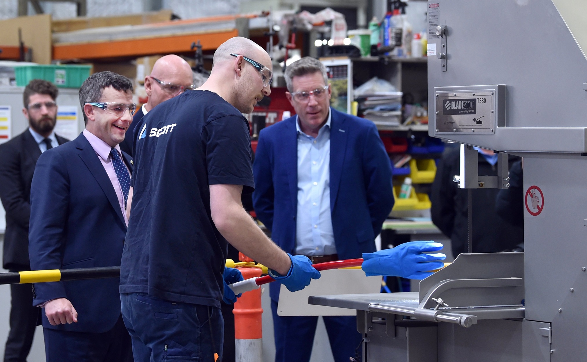 Watching a demonstration of Scott Technology’s BladeStop safety bandsaw on the factory floor are ...