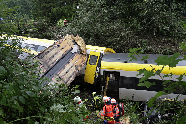 Rescue workers search for passengers in the derailed train in the Biberach district between the...