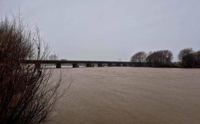 A fast-flowing and swollen Motueka River under the State Highway 60 bridge between Riwaka and...