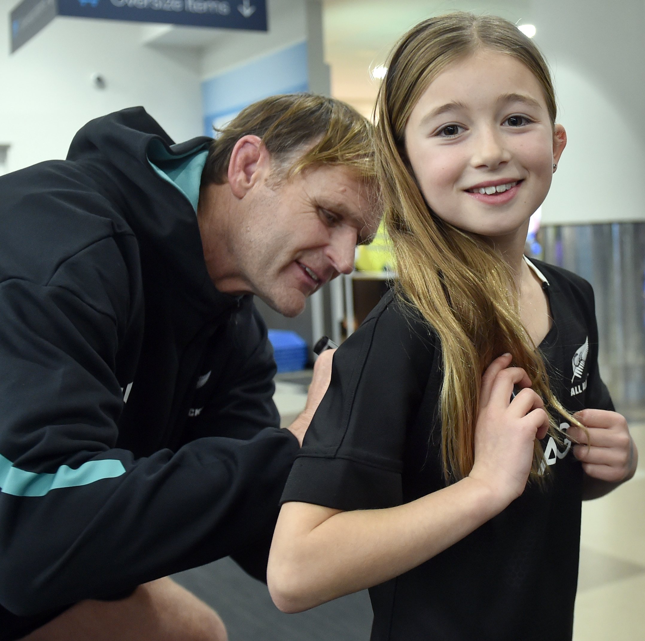 All Blacks coach Scott Robertson signs the shirt of fan Avaley Bambry, 9, of Dunedin, at Dunedin...