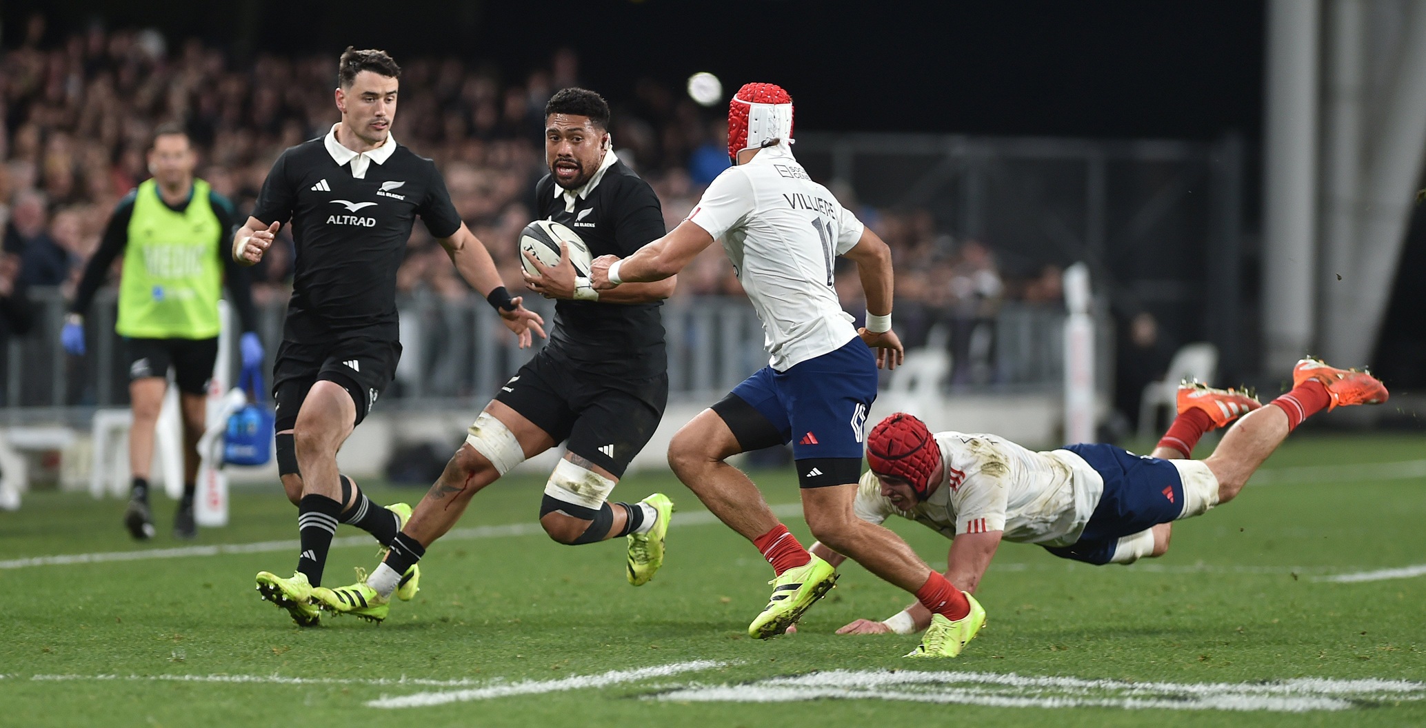 Ardie Savea has Will Jordan in support as he tries to beat French defenders Gabin Villiere and...
