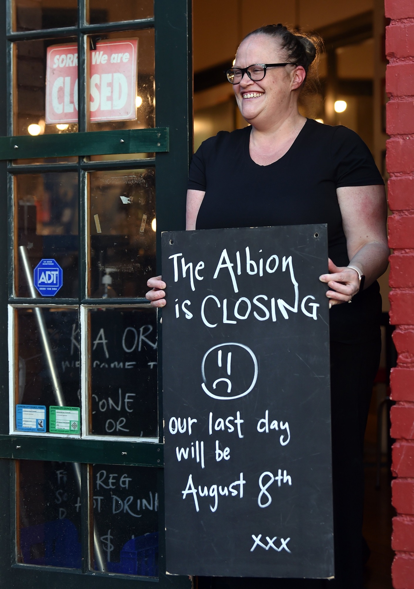 The Albion owner Jayde Regassa sets out a sign to notify customers her central city cafe will...