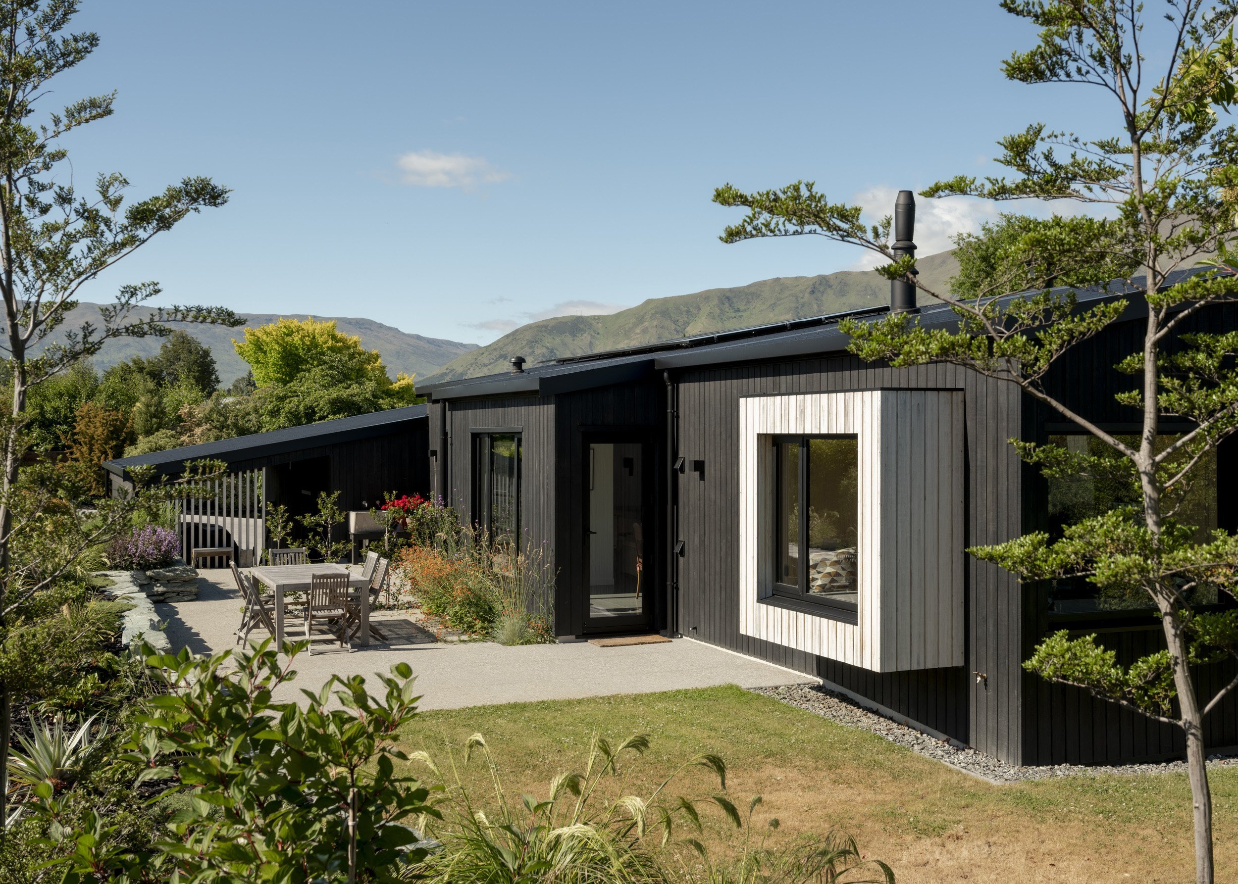Black-stained exterior timber contrasts with a warm interior palette.