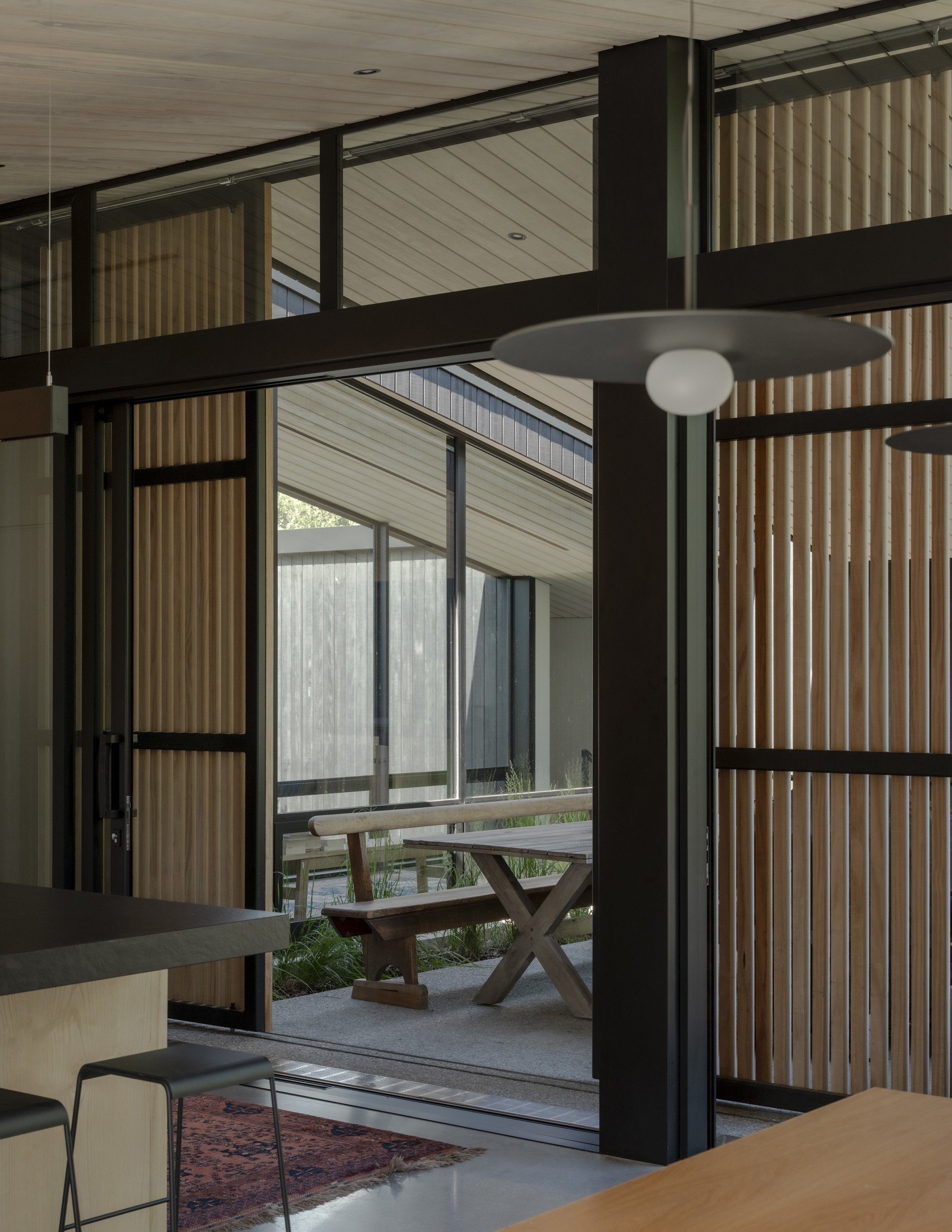 A partial concrete wall divides the dining area from the living room while maintaining a sense of...
