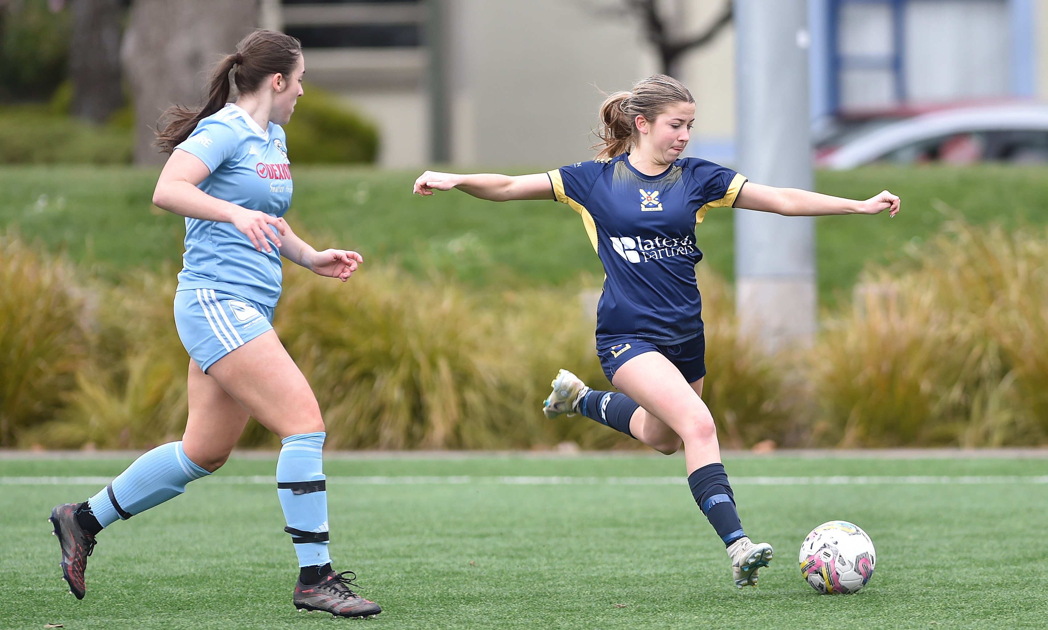 Ruby Braithwaite (right), of Otago University, looks to deliver a long ball as Sophie Hawkins, of...