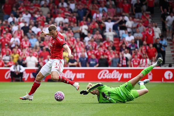 Chris Wood of Nottingham Forest goes around goalkeeper Caoimhin Kelleher of Brentford to score...