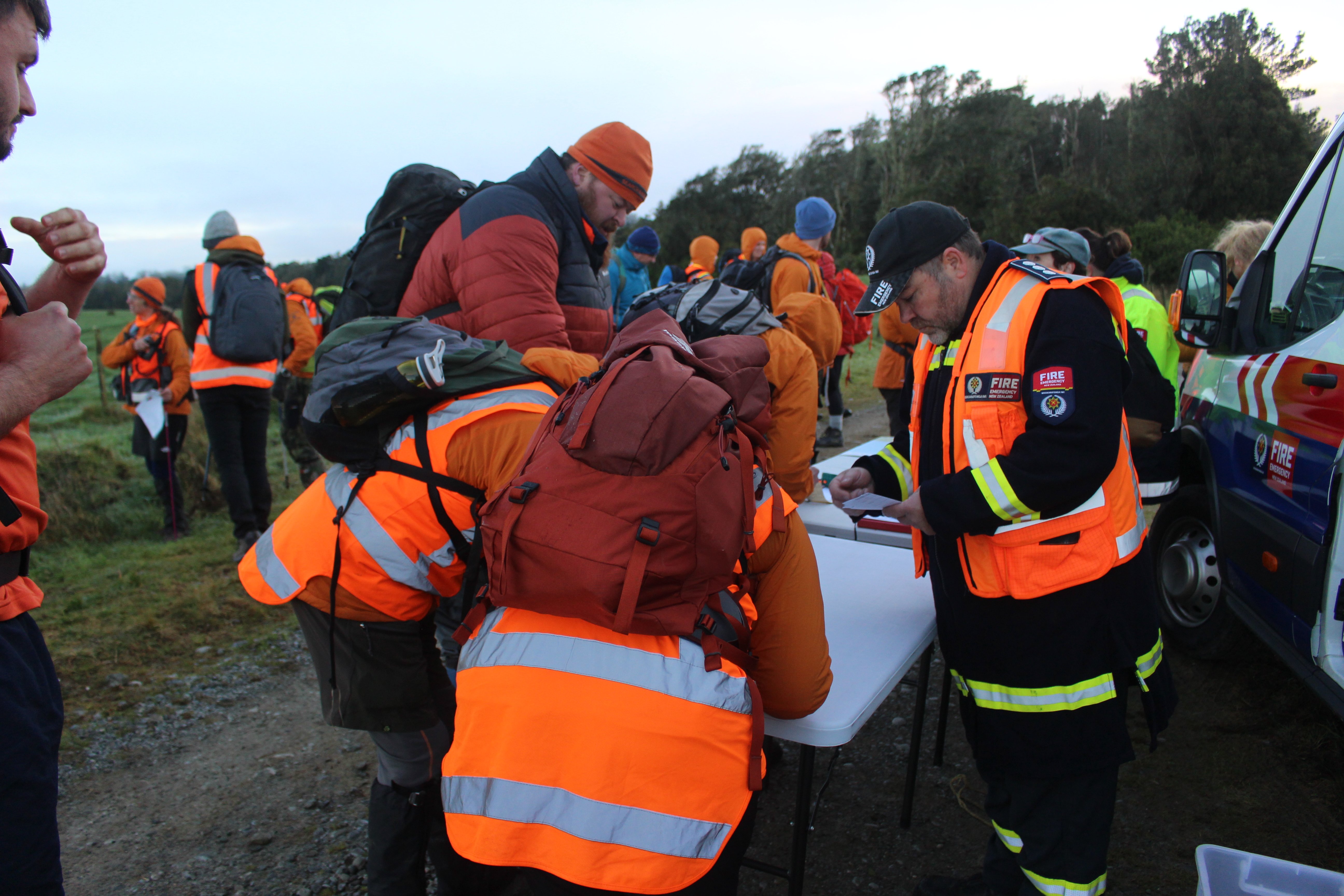 Fire and Emergency New Zealand personnel and LandSAR volunteers gather at the command centre set...