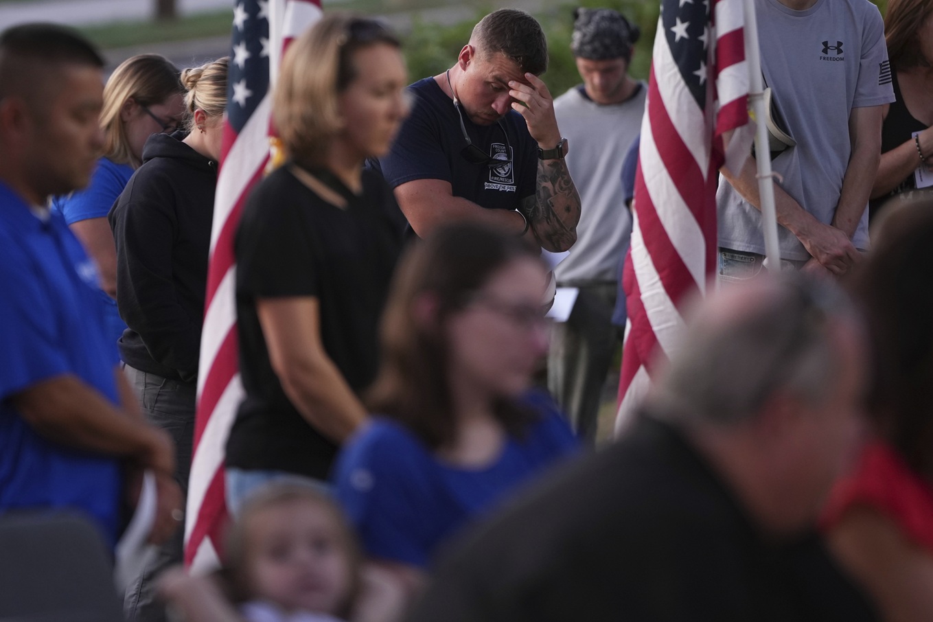 People attend a vigil honouring the shooting victims at Spring Grove Alliance church in Spring...