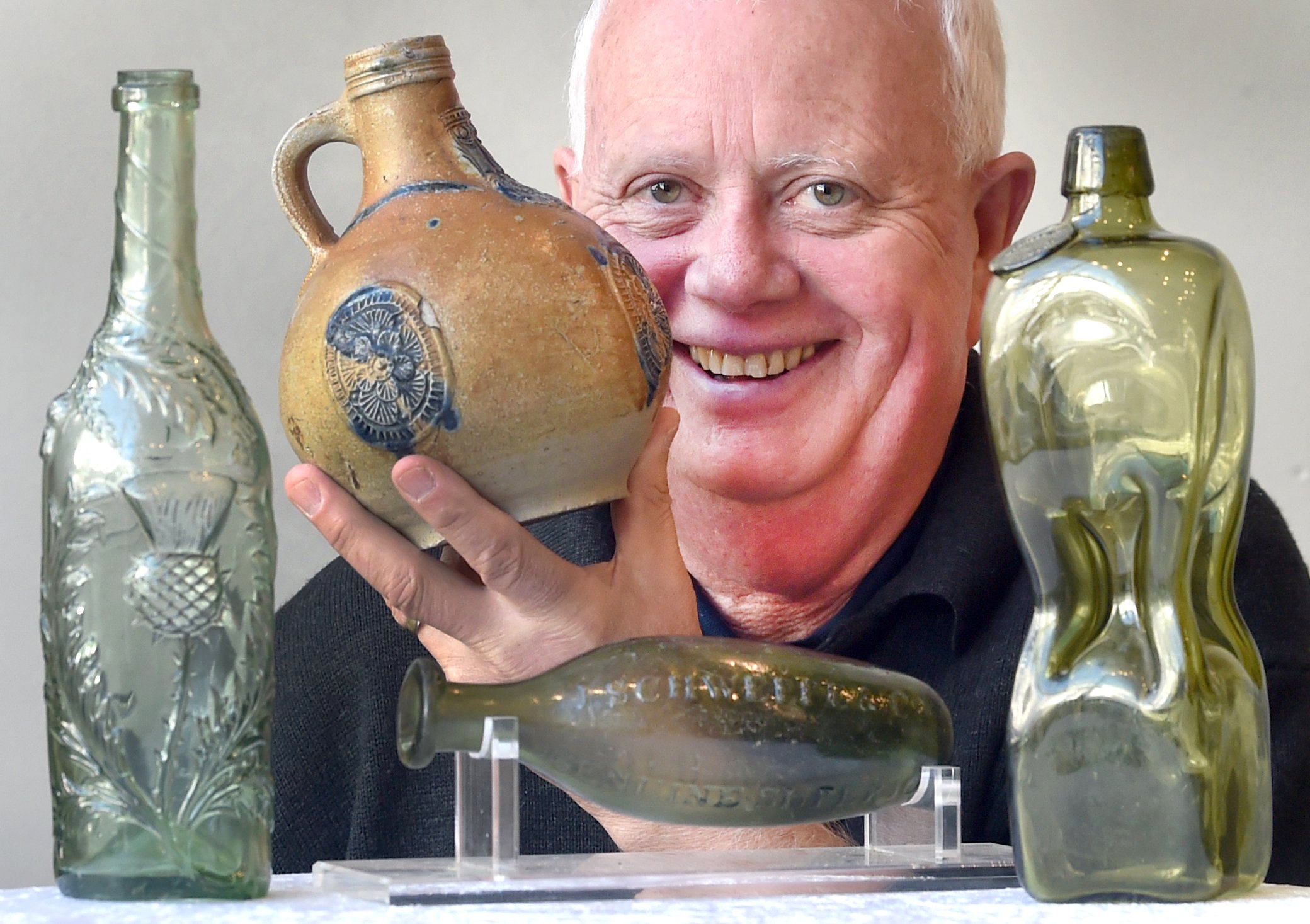 New Zealand Bottle Clubs national convener Warren Roberts holds a Bellarmine pottery wine bottle...