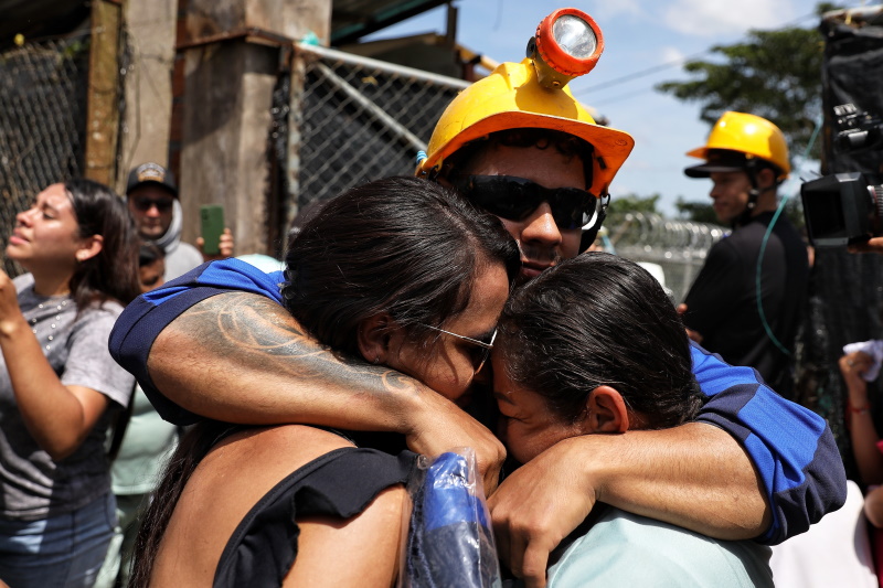 A miner embraces his relatives after he was rescued from a gold mine that had collapsed in...
