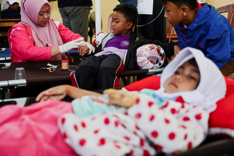 Students receive treatments for food poisoning after eating government-sponsored free school...