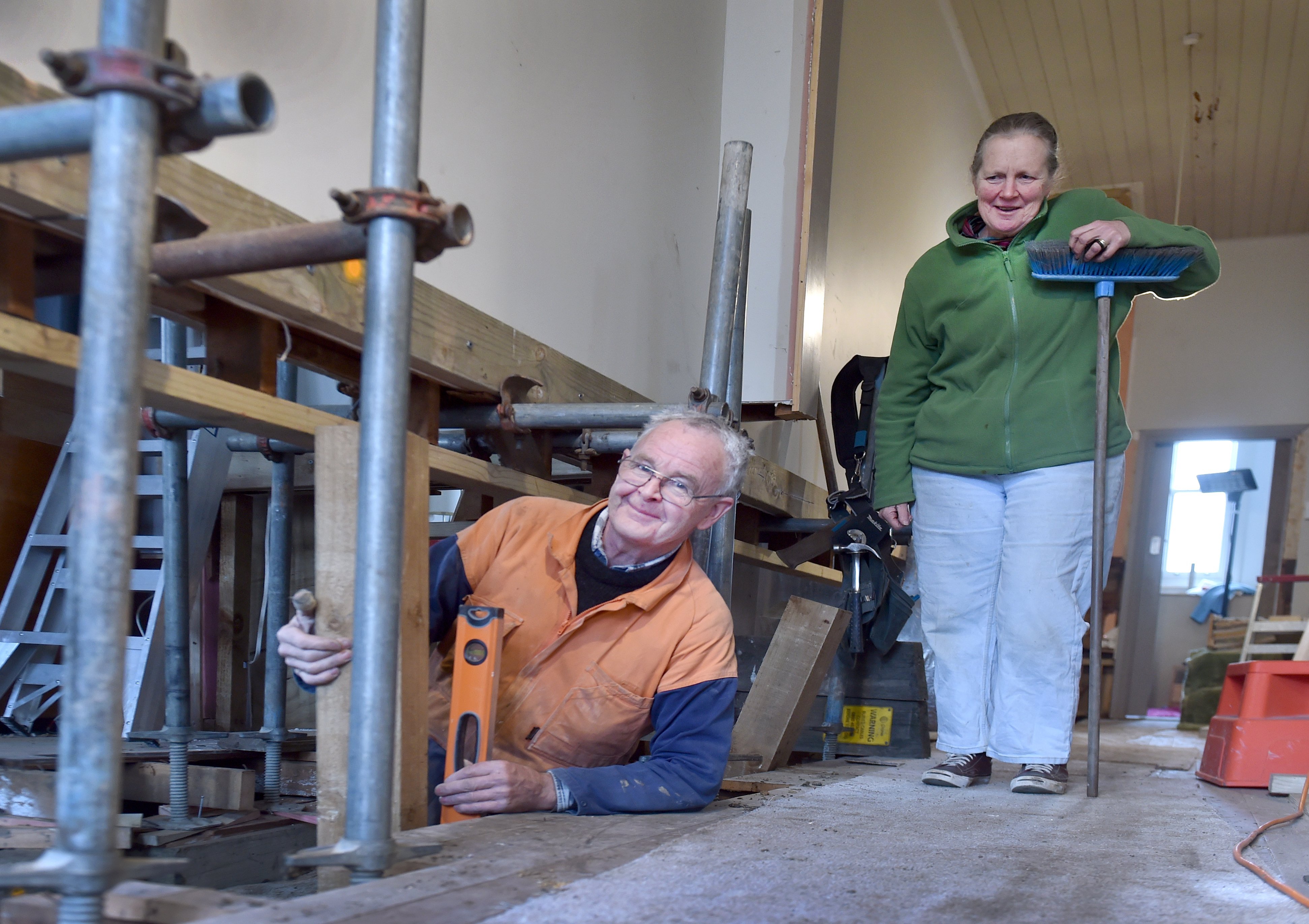 South Dunedin resident Marion McManus watches as builder Ken Close lifts the floorboards in her...