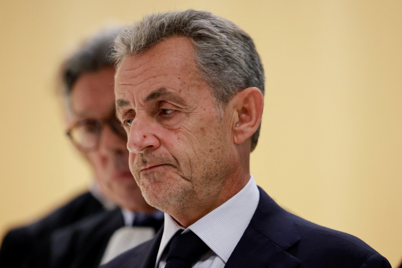 Former French President Nicolas Sarkozy reacts as he talks to journalists after the verdict in...