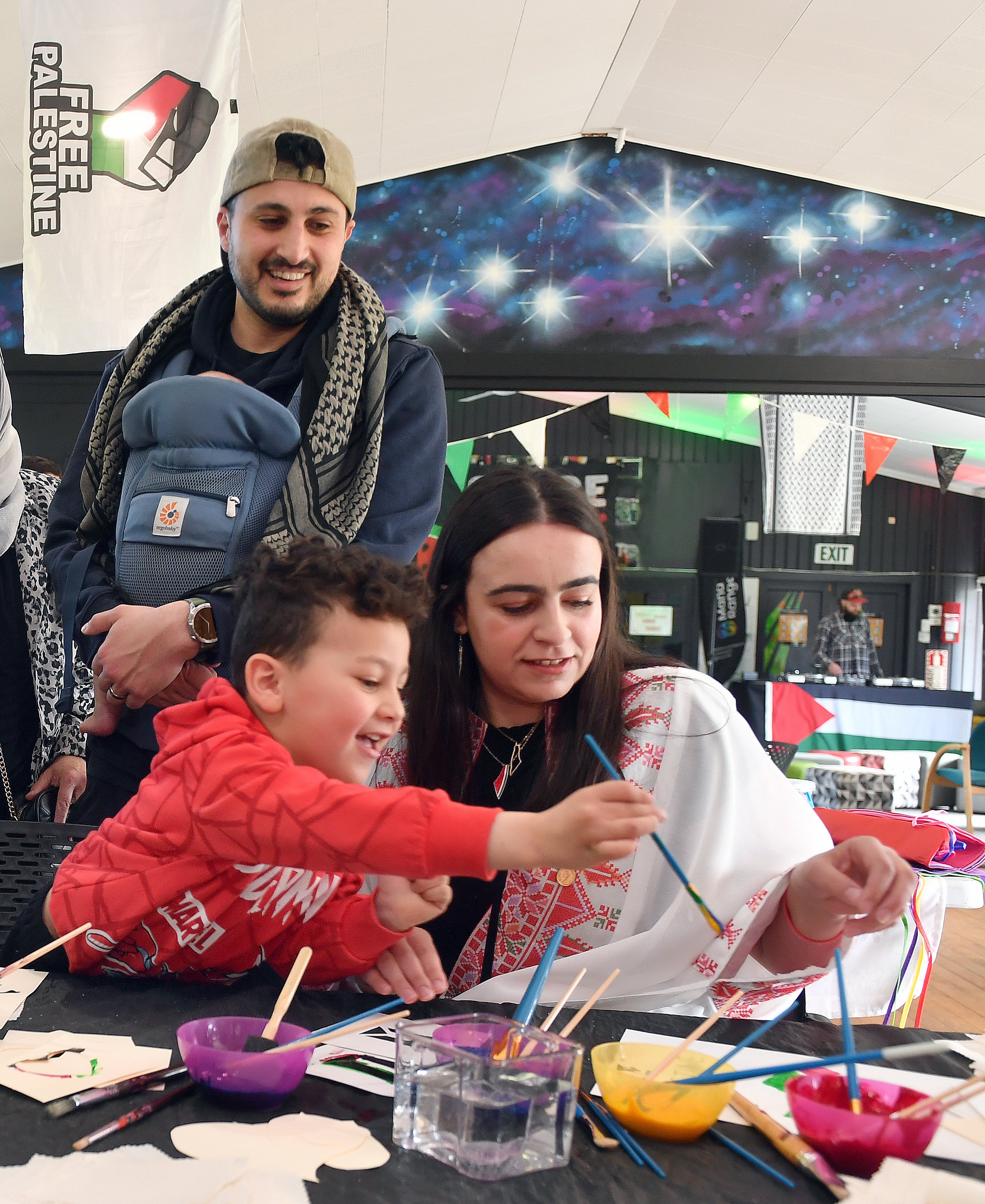 Rayan Mustaffa, 4, paints a Palestinian flag at a fundraiser in Dunedin yesterday, while father...