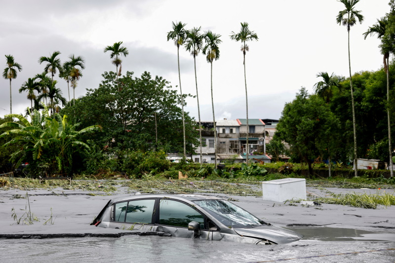 A car is partially submerged following flooding brought by Super Typhoon Ragasa in Hualien,...
