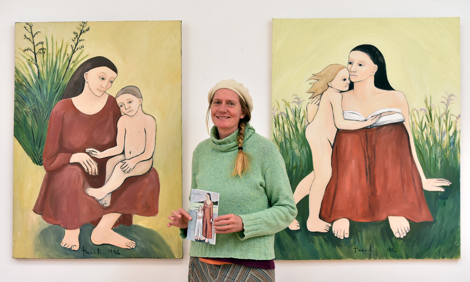 South African painter Thandi Sliepen stands in front of two of her paintings from her Aramoana...