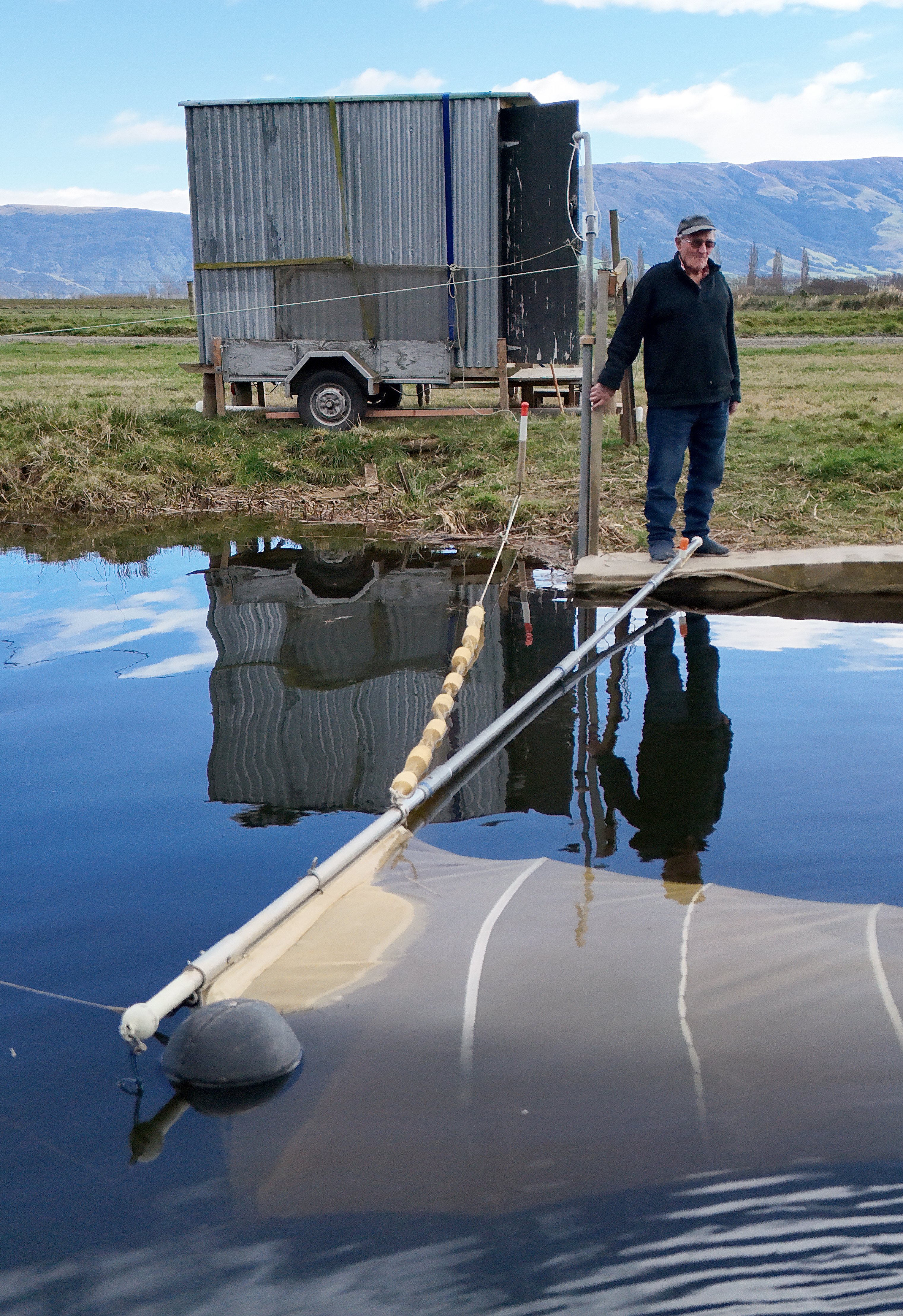 Bryan Rougham and "the toilet" wait for the whitebait to start running at his stand on the Taieri...