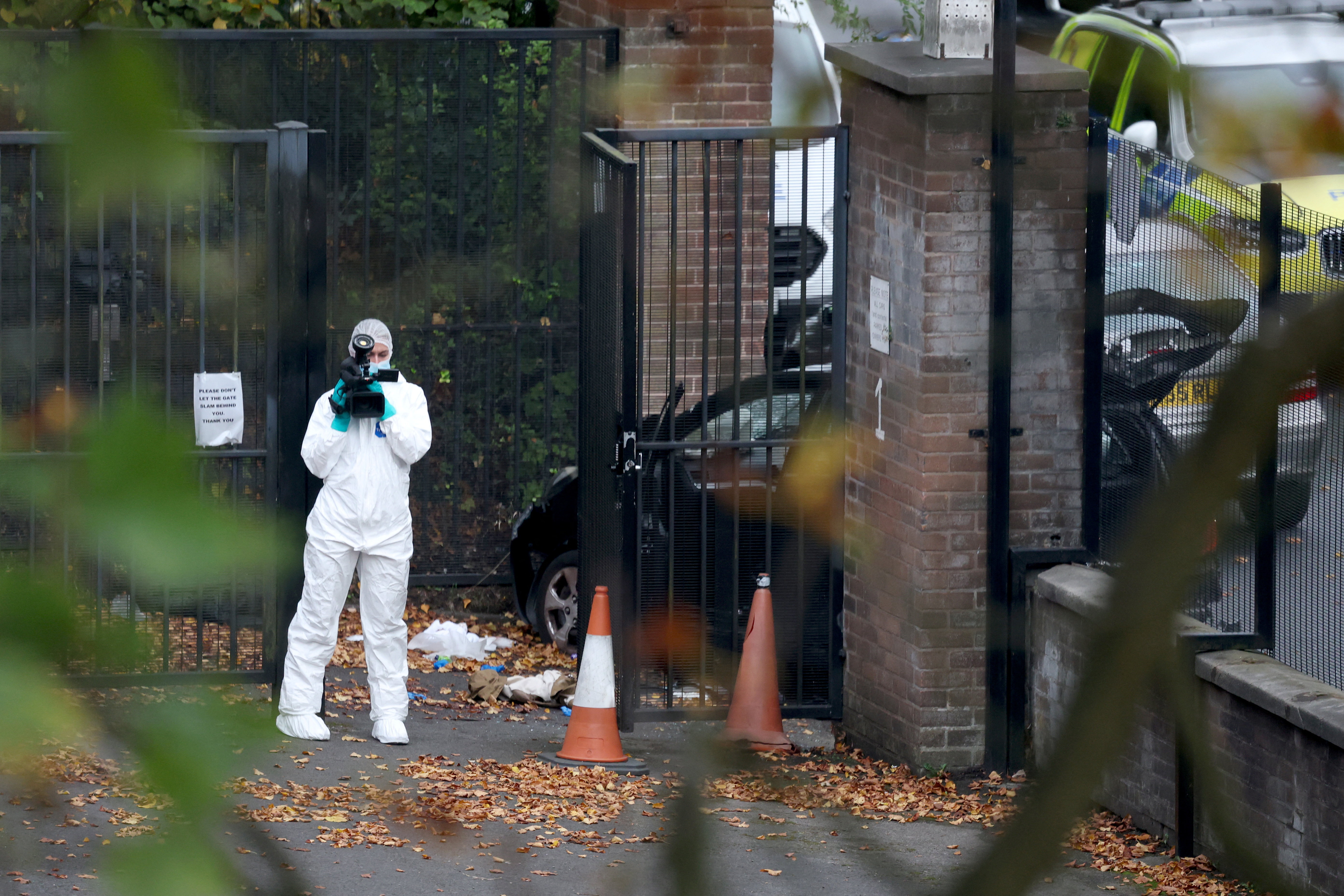 A forensic technician works at the scene after a car was driven at pedestrians and a stabbing...