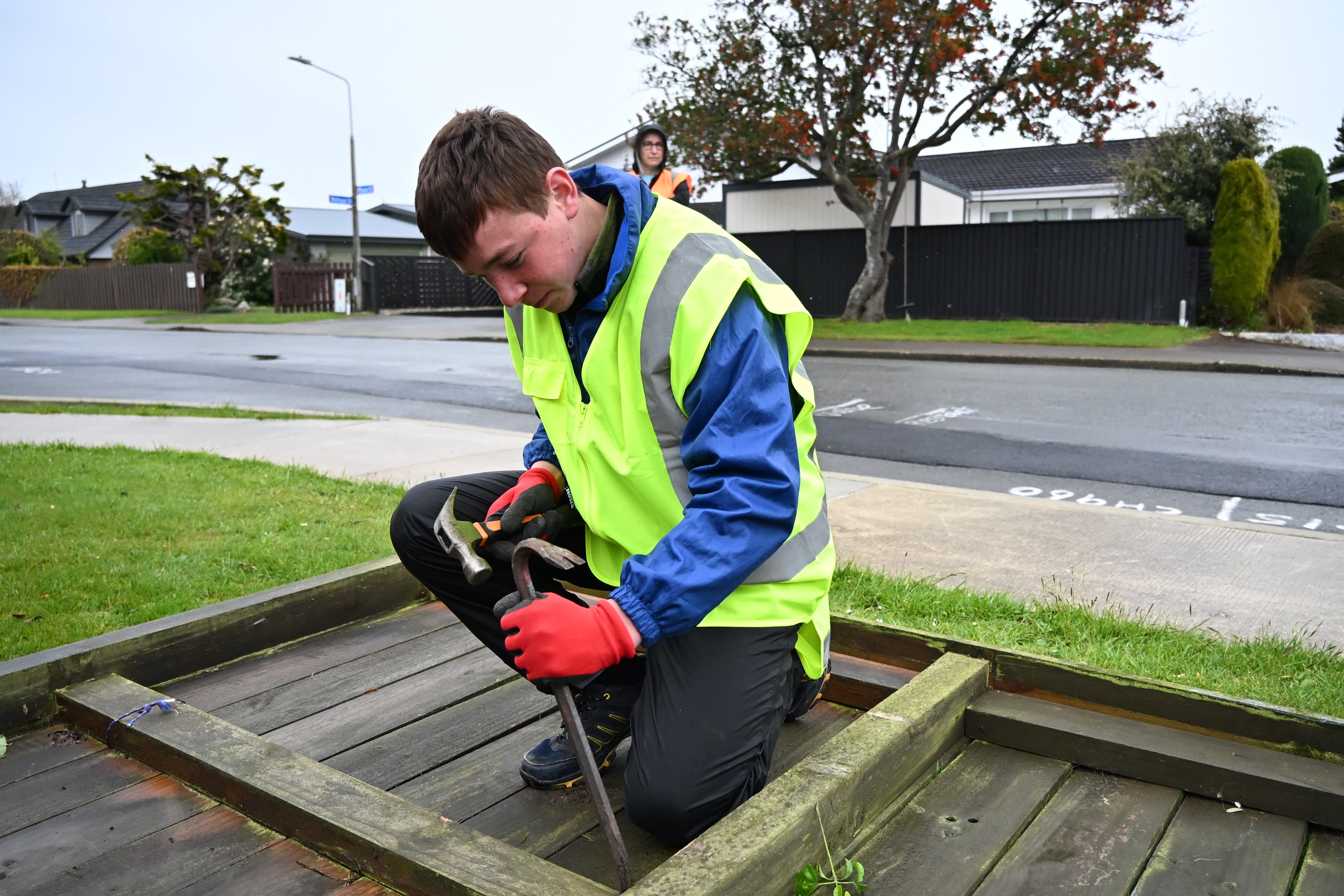 Invercargill Student Volunteer Army member Rylan Scott, 14, dismantles a fence which fell over in...
