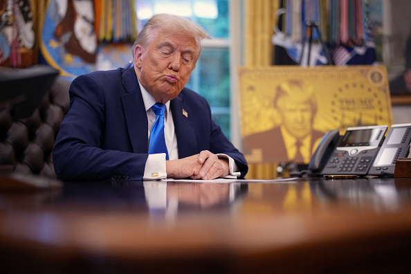 Donald Trump studies a letter, although not the one from George Warren. Photo: Getty Images