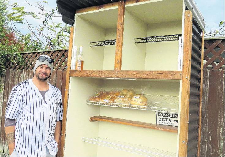 Tk Paul with the community food pantry in 2023, which has now been taken from Chalmers Ave. PHOTO...