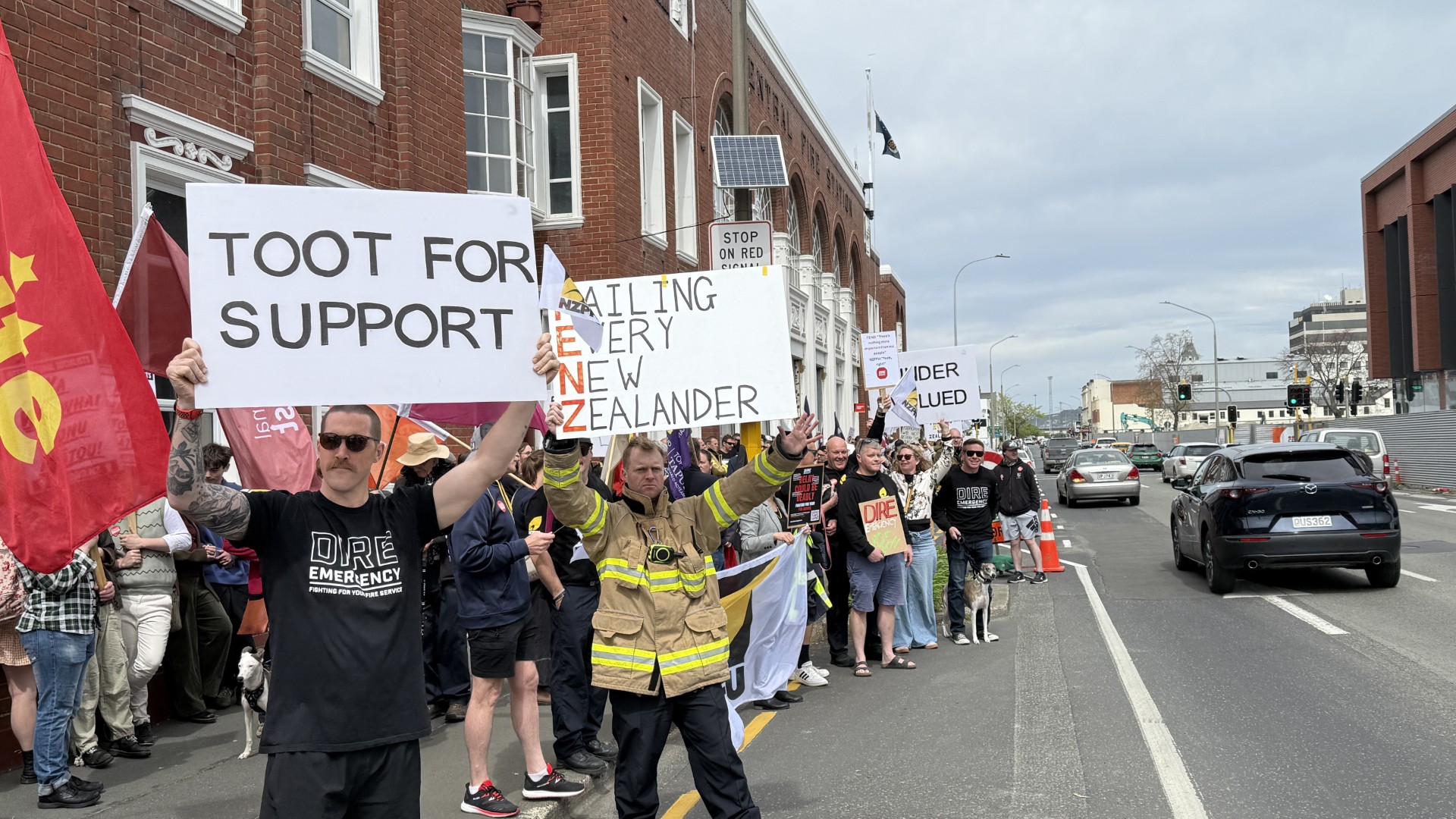 Striking firefighters acknowledge toots of support from passing motorists. PHOTO: CRAIG BAXTER