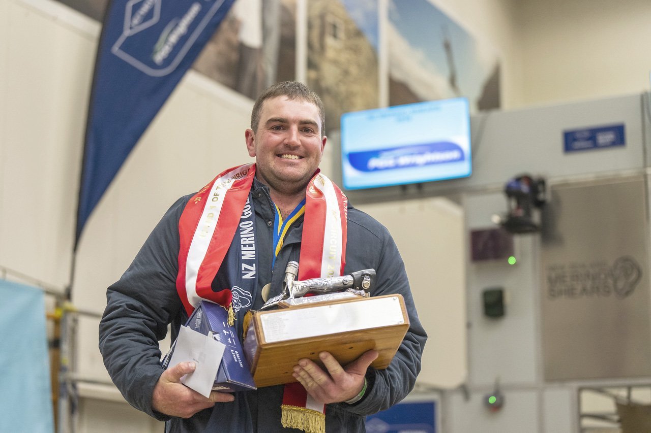 Receiving his trophy is New Zealand Merino Shears Open shearing final winner Jamie Boothman, of...