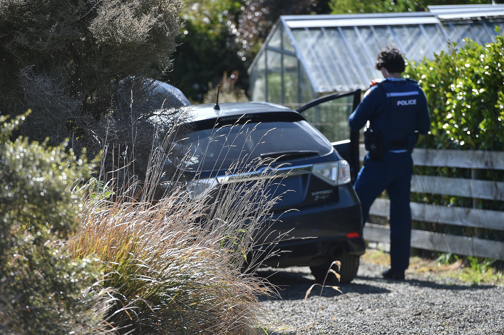 Police search the spiked car yesterday. PHOTO: GREGOR RICHARDSON