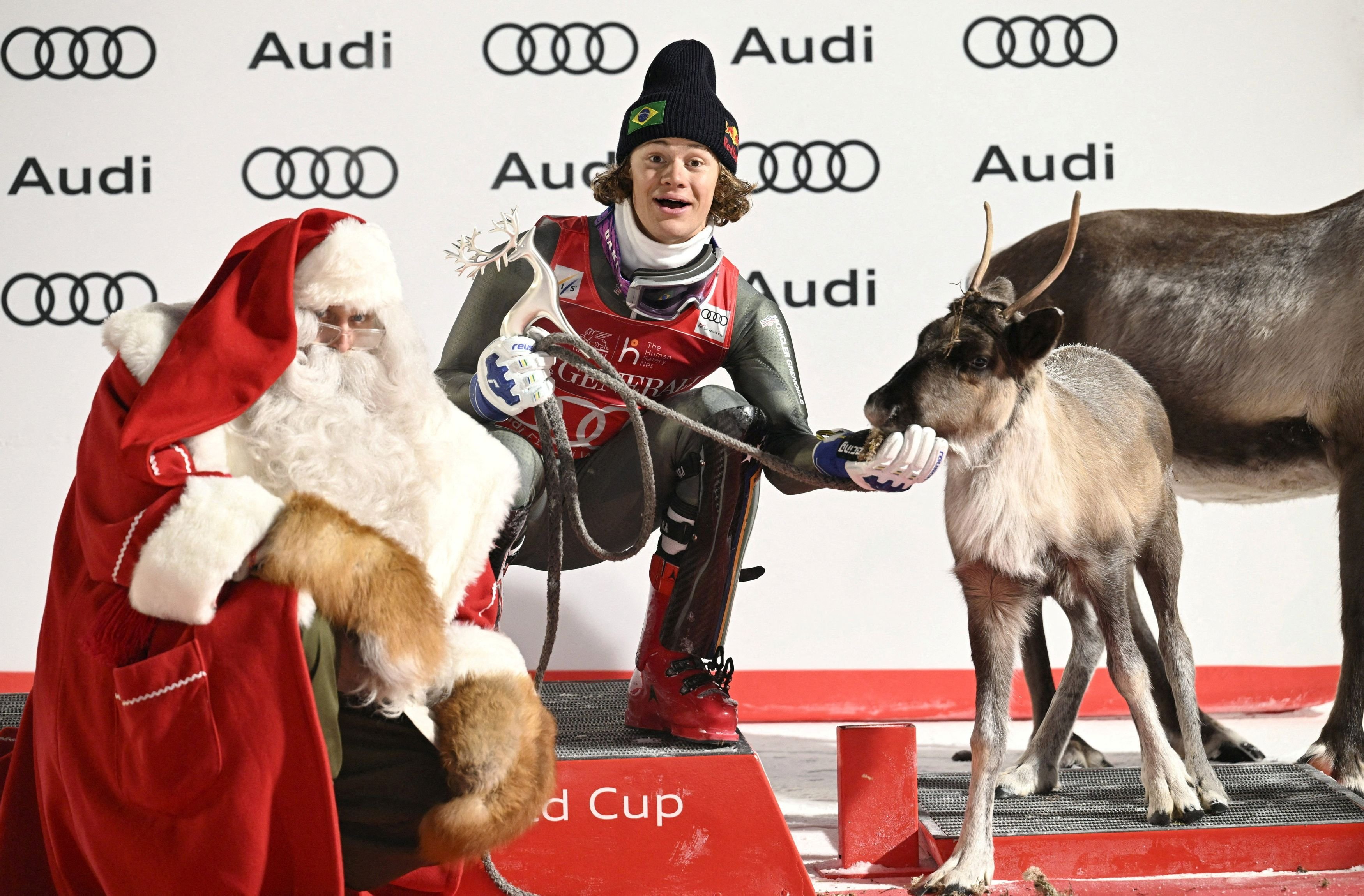 Brazilian skier Lucas Pinheiro Braathen feeds one of Santa Claus’ reindeer after winning the men...