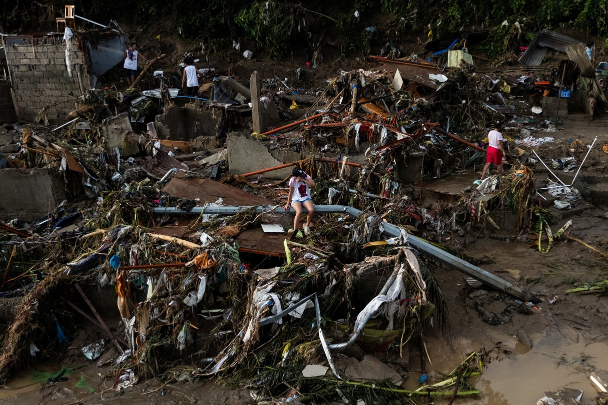 A woman sits on a fallen post amid the damage caused by Typhoon Kalmaegi in Talisay, in the...