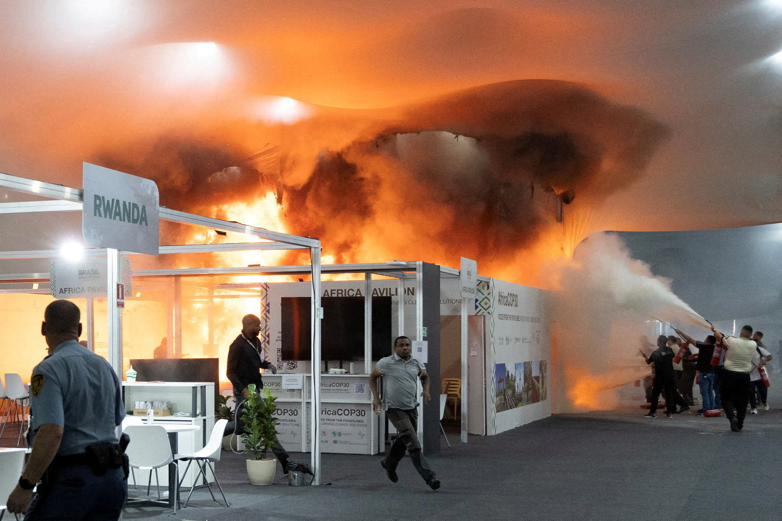People use fire extinguishers to put out a fire at the Pavilion of Countries in the Blue Zone at...