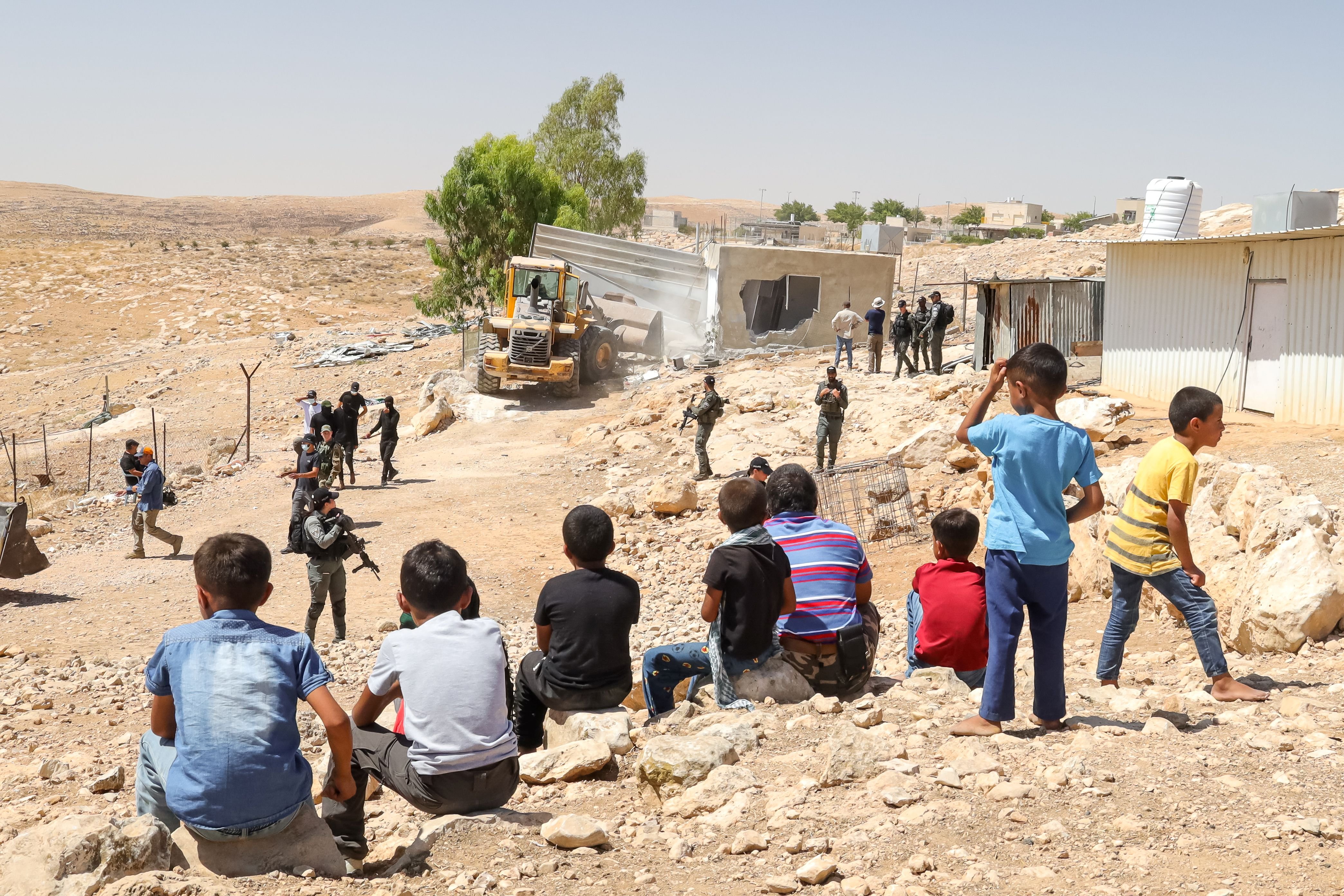 Children watch their homes being destroyed in Amm al-Khair. The Palestinian village is in the...